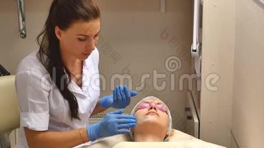美容师用面霜和按摩妇女在水疗中心进行美容治疗。 专业美容师